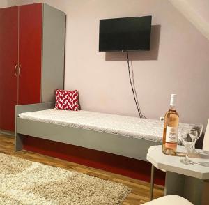 a bedroom with a bed with a tv on the wall at Guest House Aleksandra in Bajina Bašta