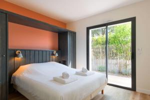 ein Schlafzimmer mit einem Bett mit zwei Handtüchern darauf in der Unterkunft "NOLA" Charmante Villa contemporaine et spacieuse in La Flotte