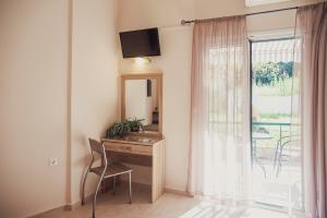 a room with a desk and a mirror and a window at Maria Olga Apartments in Benitses