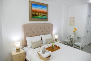 a bedroom with a large white bed with a basket on it at Ecusuites Playas premium Room 2 - Villamil data in Playas +30 photos