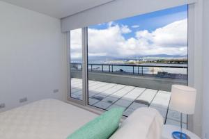 sypialnia z dużym oknem z widokiem na ocean w obiekcie Pacífico Apartamentos Centro w mieście Ushuaia