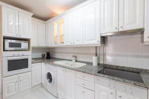 a white kitchen with a sink and a microwave at Botanika - Baskey Rentals in Lekeitio