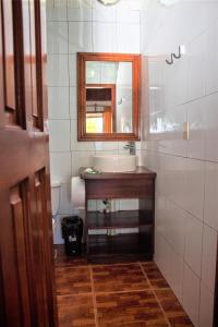 a bathroom with a sink and a mirror at Coconut Tree West Bay in West Bay