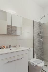a white bathroom with a sink and a toilet at Maria Olga Apartments in Benitses +48 photos