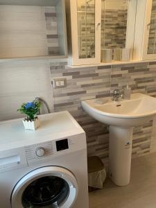 een badkamer met een wasmachine en een wastafel bij America in Oliveri
