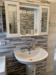een badkamer met een wastafel en een spiegel bij America in Oliveri