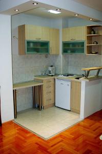 a kitchen with wooden cabinets and a white appliance at Apartment GORDANA in Ohrid