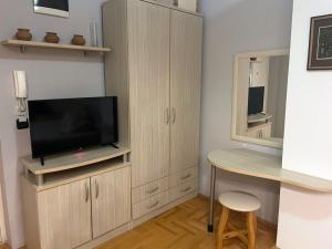 a living room with a tv and a table and a desk at Apartment GORDANA in Ohrid