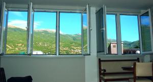 a room with three windows with a view of a mountain at Apartment GORDANA in Ohrid +1 photo