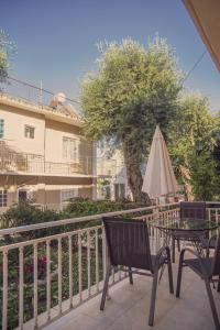 a patio with a table and an umbrella at Maria Olga Apartments in Benitses