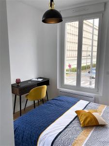 een slaapkamer met een bed, een bureau en een raam bij Ponsardin #55 spacieux appartement 3 ch 6 couchages in Reims