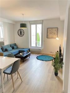 - un salon avec un canapé bleu et une table dans l'établissement Ponsardin #55 spacieux appartement 3 ch 6 couchages, à Reims
