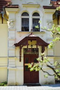 ein Gebäude mit einer braunen Tür und zwei Fenstern in der Unterkunft Apartmán Zahrádka in Česká Lípa