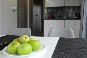 Miska jabłek na talerzu na stole w obiekcie Hausboat Kamien Pomorski 20 m2 for 3 persons on the water w mieście Kamień Pomorski