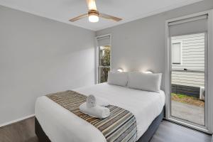a bedroom with a white bed with a window at Ingenia Holidays Middle Rock in One Mile