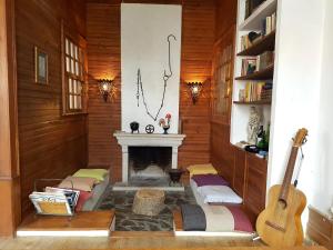 ein Wohnzimmer mit einem Kamin und einer Gitarre in der Unterkunft Casa da Vila in Penamacor