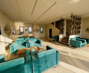 a living room with blue couches and a staircase at Hotel Atlantis Mazagan in Douar Draoud