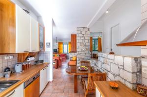a kitchen and living room with a table and chairs at bougainvilla in Fodele +30 photos