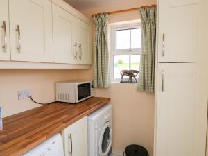 a laundry room with a washer and dryer and a window at Grange Farmhouse in Fethard on Sea