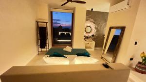 um quarto com uma cama e uma grande janela em Tikul Hotel Boutique em Holbox