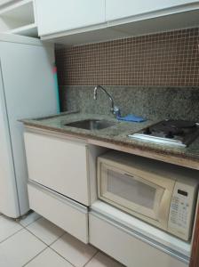 a kitchen with a sink and a microwave at Flat Experience Marulhos Resort in Porto De Galinhas