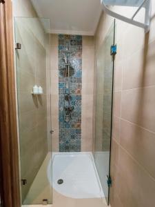 a bathroom with a shower with a glass door at Hotel Atlantis Mazagan in Douar Draoud