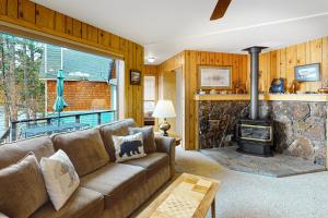 a living room with a couch and a stone fireplace at The Treehouse in Joseph
