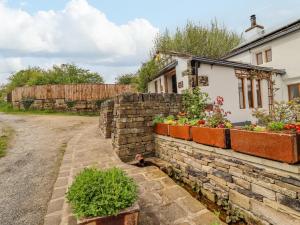 a brick retaining wall with flowerpots on the side of a house at The Dairy in Haworth