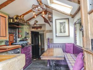 a kitchen with a wooden table and purple cabinets at The Dairy in Haworth