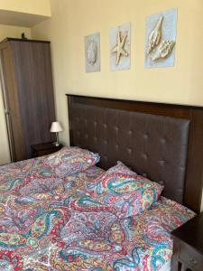 a bedroom with a bed with a comforter and pictures on the wall at Barcelo Royal Beach Private Apartment in Sunny Beach +16 photos