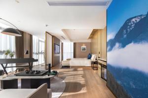 Una sala de estar con una cama y un televisor. en Atour S Hotel Wuhan Chuhehanjie, en Wuhan