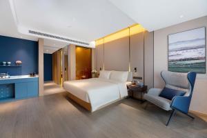 a bedroom with a bed and a desk and a chair at Atour Hotel Hengyang South Mountain Hengshan Scenic Area in Nanyue