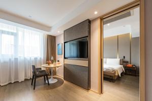 a hotel room with a bed and a table at Atour Hotel Shijiazhuang East Zhongshan Road in Shijiazhuang