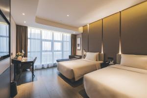 a hotel room with two beds and a desk at Atour Hotel Shaoxing Shangyu E-Travel Town in Shaoxing