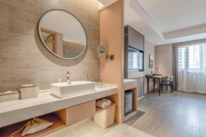 a bathroom with a sink and a mirror at Atour Hotel Taizhou Maoye World in Taizhou