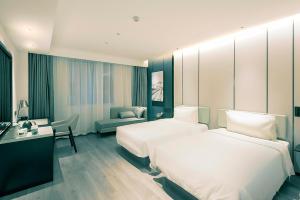 a hotel room with two beds and a desk at Atour Hotel Wuhan Optics Valley Square Yangjia Bay in Wuhan