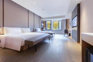 Pokój hotelowy z dużym łóżkiem i biurkiem w obiekcie Atour Hotel Nanjing Xianlin Unviersity Town w mieście Nankin