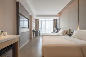 a hotel room with two beds and a fireplace at Atour Hotel Yizheng Wannian Avenue in Yizheng