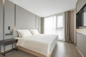 Säng eller sängar i ett rum på Atour Hotel Taizhou Maoye World