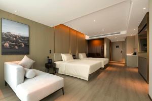 a hotel room with two beds and a couch at Atour Hotel Wuhan Hankou Financial Center in Wuhan