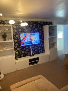 a living room with a flat screen tv on a wall at Lovely 2 Bed Flat/Apt in East London- Nice Estate. in Dagenham