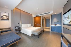 a bedroom with a large white bed and a bathroom at Atour Hotel Kunshan Baoyu Plaza North Changjiang Road in Kunshan +11 photos