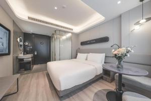 Un dormitorio con una gran cama blanca y una mesa en Atour Light Hotel Chengdu Wide-Narrow Alley, en Chengdú