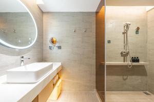 een badkamer met een wastafel en een douche bij Atour Hotel Huai an Suning Plaza Dazhi Road in Huai'an