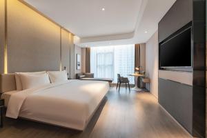 a hotel room with a large white bed and a television at Atour Hotel Xian Economic Development Zone Fengcheng 5th Road in Xi'an