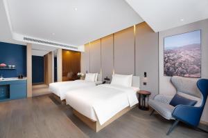 a hotel room with three beds and a chair at Atour Hotel Hengyang South Mountain Hengshan Scenic Area in Nanyue +13 photos