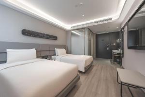 a hotel room with two beds and a television at Atour Light Hotel Nantong Drum Plaza South Street in Nantong