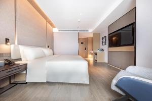 a hotel room with a large bed and a television at Atour Hotel Wuhan Yellow Crane Tower in Wuhan +20 photos