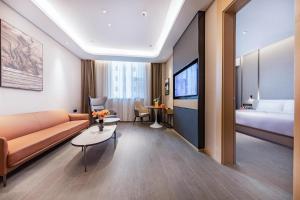 ein Hotelzimmer mit einem Sofa und einem Bett in der Unterkunft Atour Hotel Taiyuan Changfeng Business Center Wanxiang City in Taiyuan