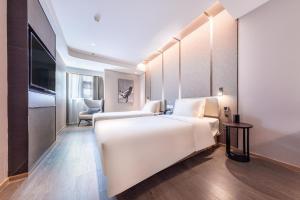 a bedroom with a large white bed in a room at Atour Hotel Wuhan Yellow Crane Tower in Wuhan